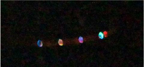 a photo depicting five lights of different colours spread across the night sky